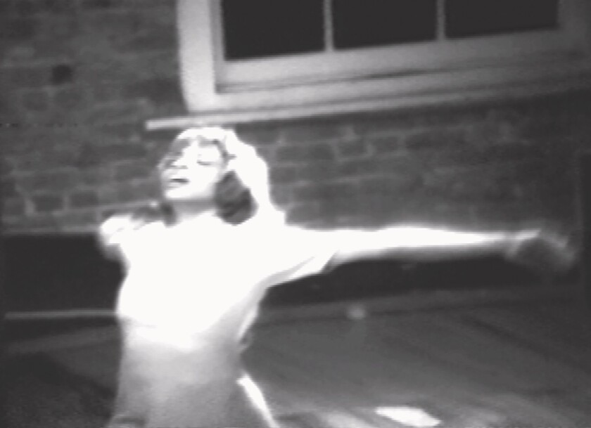 A woman spreads her arms wide in a black-and-white still from "The Ladies and Me," 1980.