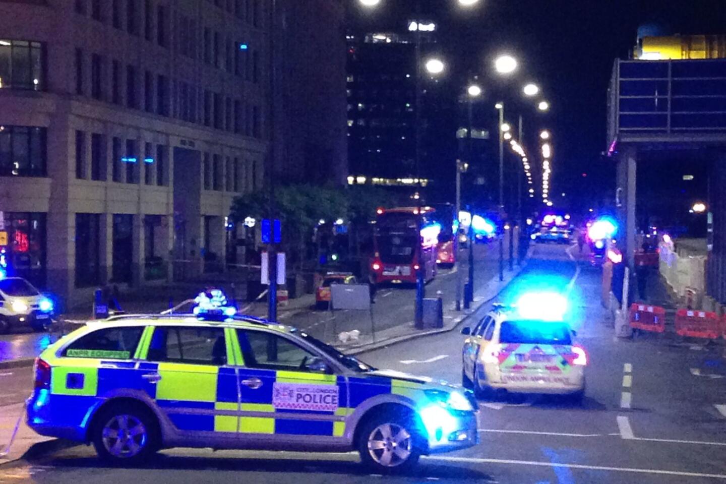 Police cars block the entrance to London Bridge after reports of the attack.