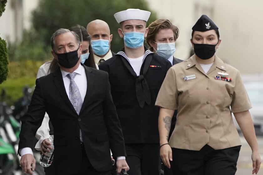 Navy Seaman Apprentice Ryan Sawyer Mays, center, arrives for a hearing at Naval Base San Diego Monday, Dec. 13, 2021, in San Diego. The Navy is set to hold a hearing to review whether there is enough evidence to order a court martial for a San Diego-based sailor charged with setting the fire that destroyed the USS Bonhomme Richard in the summer of 2020. (AP Photo/Gregory Bull)