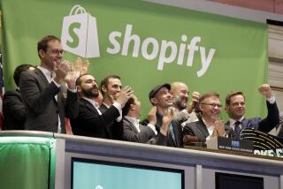 Shopify CEO Tobias Lutke, center wearing hat, is celebrated as he rings the New York Stock Exchange opening bell, marking the Canadian company's IPO, Thursday, May 21, 2015. Shopify Inc. works with merchants who want to offer their own online checkout services, providing a platform for small- and mid-size businesses that sell products online. (AP Photo/Richard Drew)