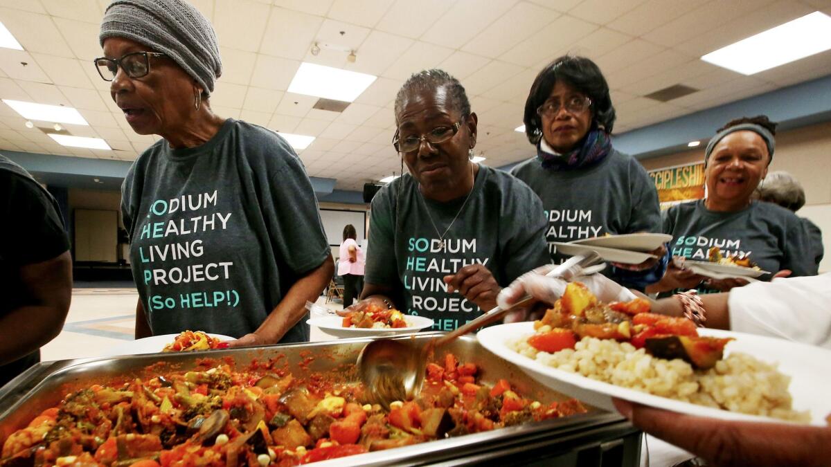 Participants in the Sodium Healthy Living Project line up for a low-sodium, vegetarian dinner at Holman Methodist Church in Los Angeles. (Luis Sinco / Los Angeles Times)