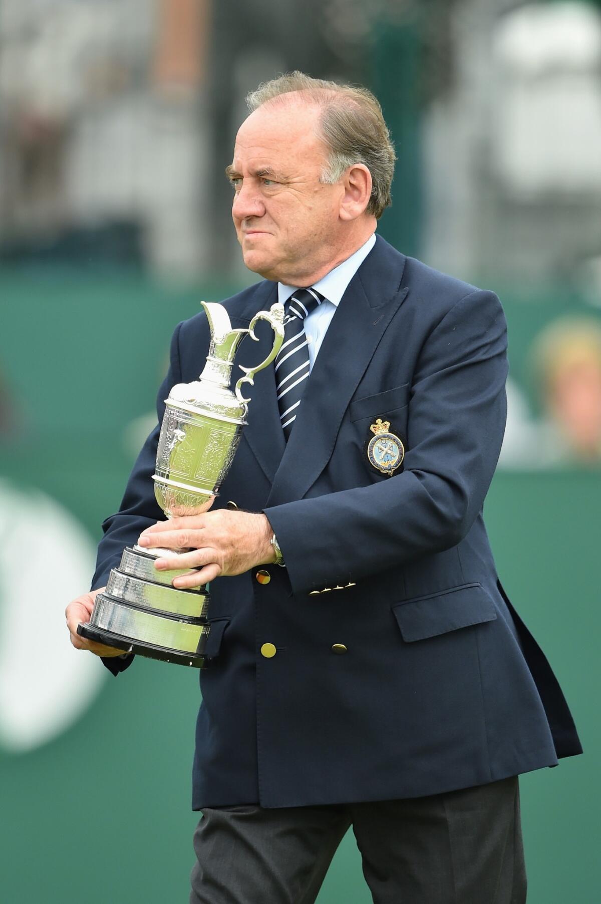 Peter Dawson, chief executive of the Royal & Ancient Golf Club, holds the Claret Jug on the 18th green after the final round of the 2014 British Open.