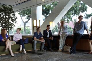 Members of Junto Global gather in the lobby of a downtown San Diego building before a group meeting. They are, from left, Kate Feick, Nicole Hubbs, Alasdair Plambeck, Parker Harris, Andrea Yoder-Clark, Chandler Perog and Camila Bernal.