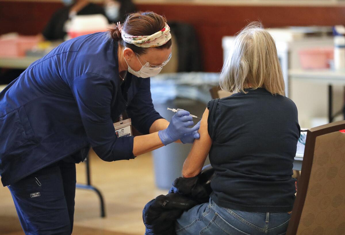 Deonne Cullen, a vocational nurse from Hoag Medical Group, administers a Phizer vaccine shot.