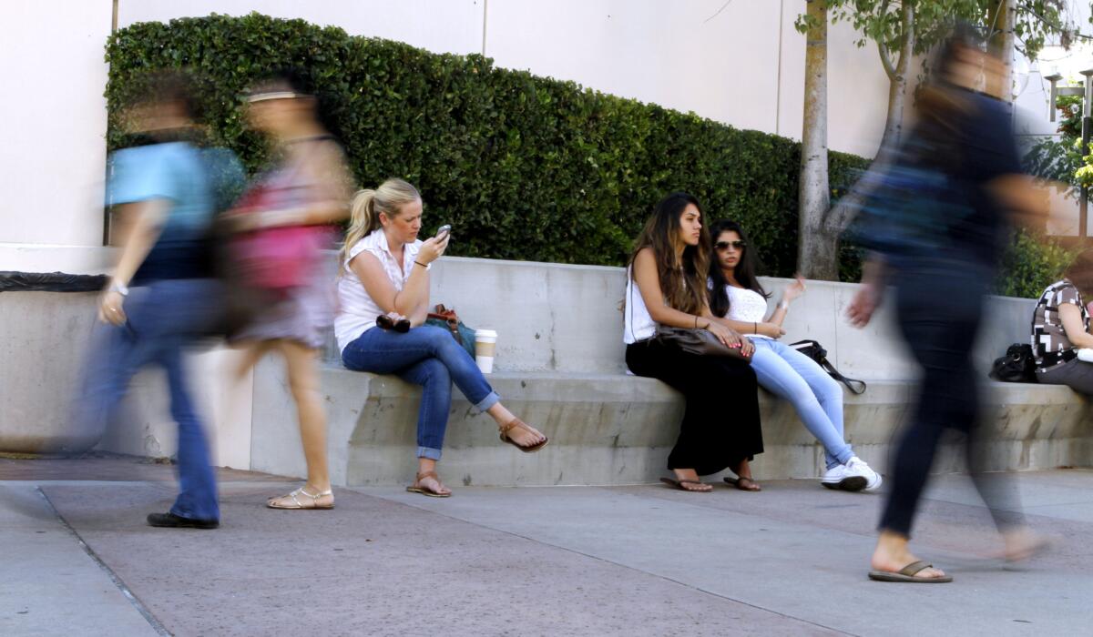 As some students wait for classes to begin, others rush to and from buildings on the first day of Fall classes at Glendale Community College on Tuesday, Sept. 3, 2013.
