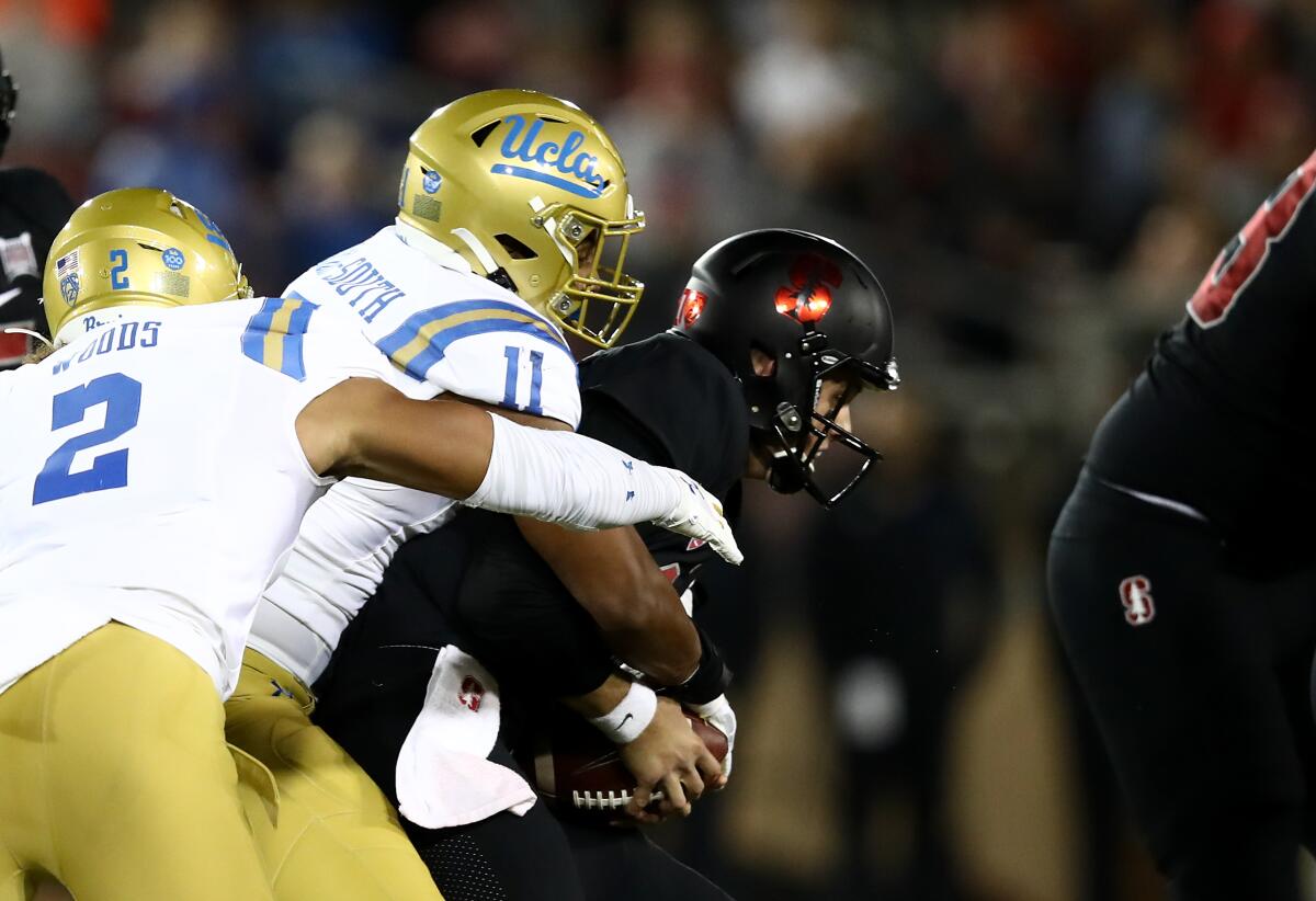 UCLA's Keisean Lucier-South (11) sacks Stanford's Jack West (10) at Stanford Stadium on Thursday in Palo Alto.