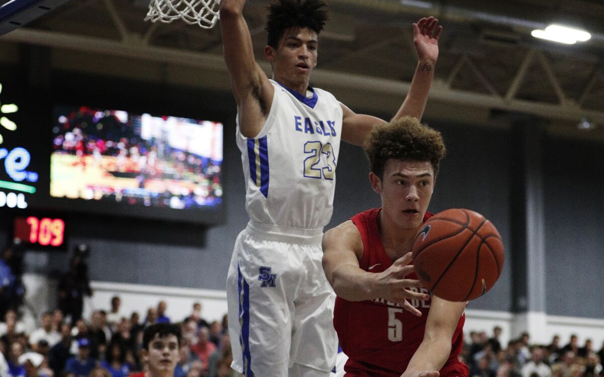 Mater Dei guard Devin Askew (5) passes after having his drive cut off by Santa Margarita's Max Agbonkpolo during a Trinity League game on Jan. 16.