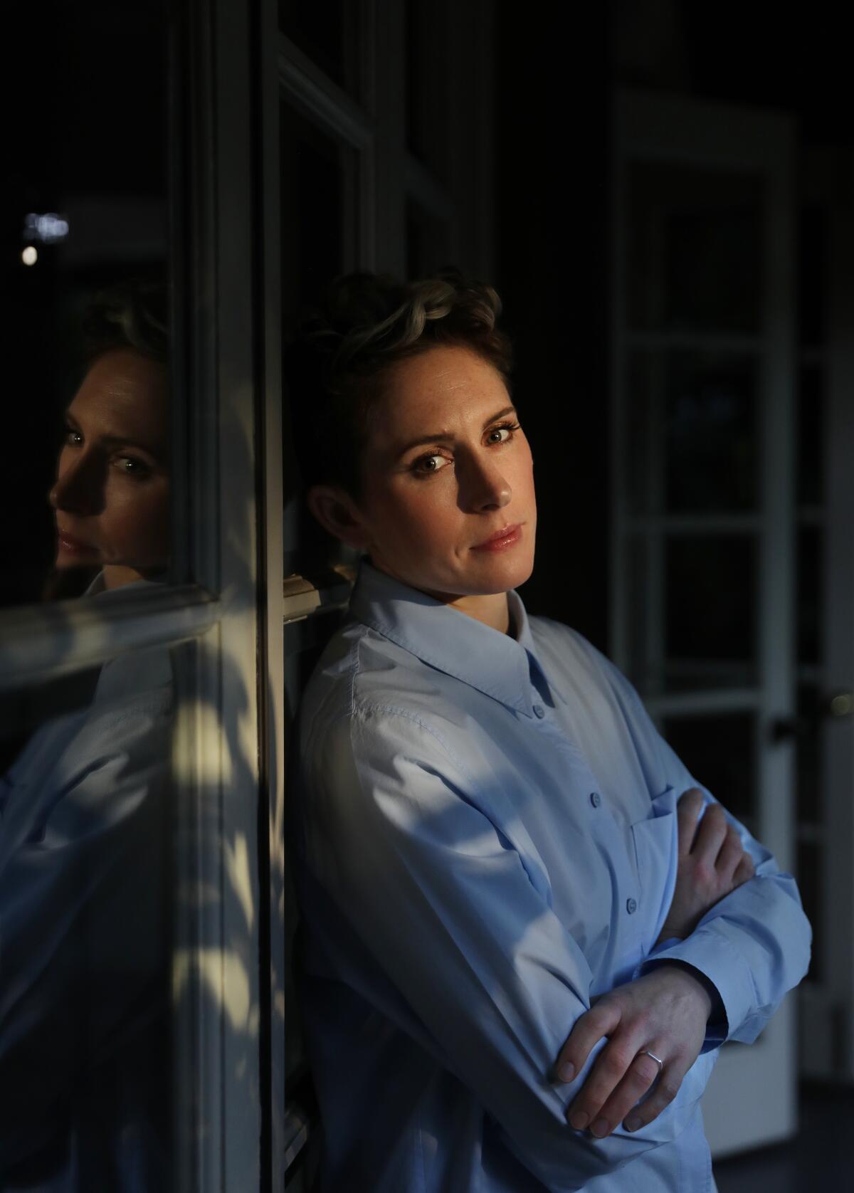 Ari Wegner, cinematographer of "The Power of the Dog" leans against french doors