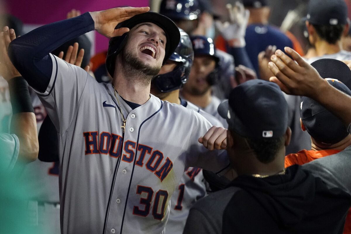 Houston Astros' Kyle Tucker (30) celebrates in the dugout after his grand slam during the fourth inning of the team's baseball game against the Los Angeles Angels on Friday, Aug. 13, 2021, in Anaheim, Calif. (AP Photo/Marcio Jose Sanchez)