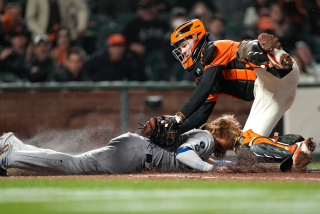 SAN FRANCISCO, CALIFORNIA - SEPTEMBER 03: Buster Posey #28 of the San Francisco Giants tags out Justin Turner.