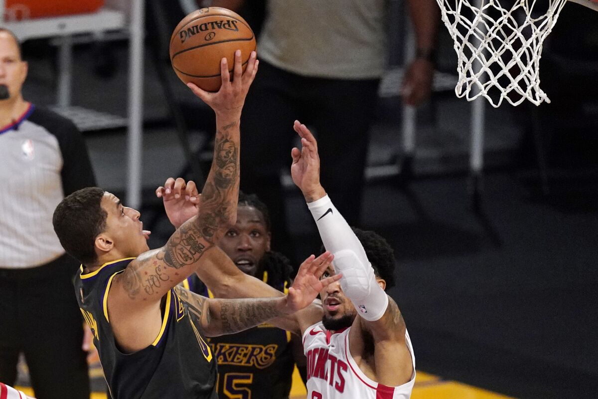Los Angeles Lakers forward Kyle Kuzma, left, shoots and scores as Houston Rockets forward Kenyon Martin Jr., right, defends in the closing seconds of the second half of an NBA basketball game Wednesday, May 12, 2021, in Los Angeles. (AP Photo/Mark J. Terrill)