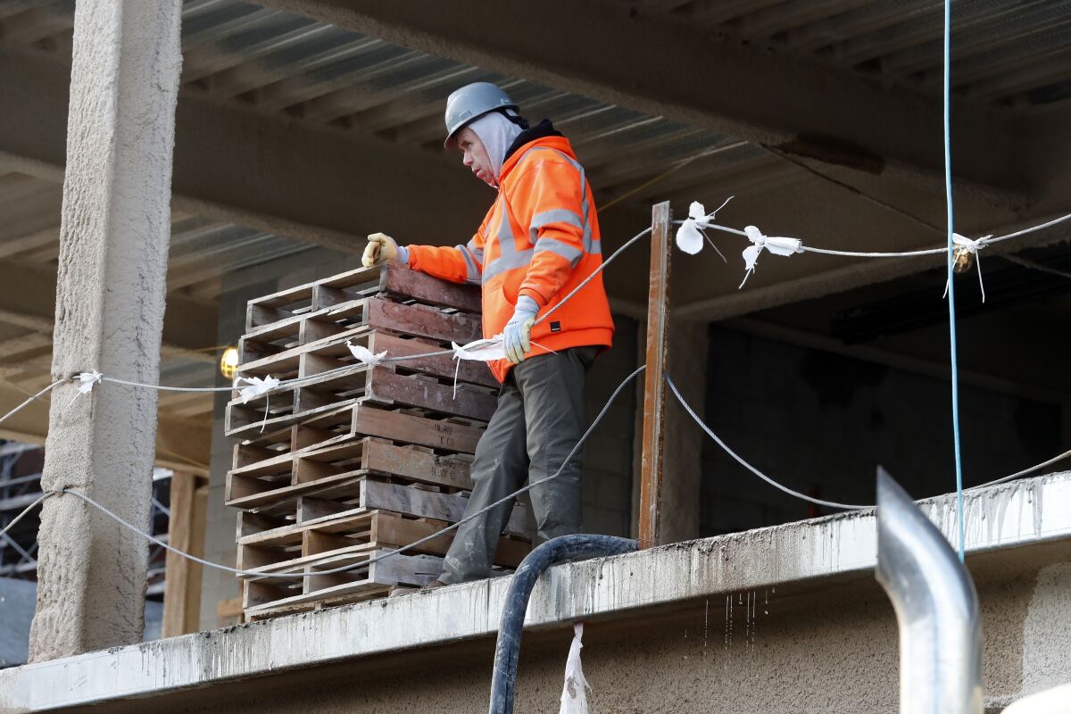 Un albañil toma una pausa en un sitio de construcción, el jueves 26 de enero de 2023 en Boston