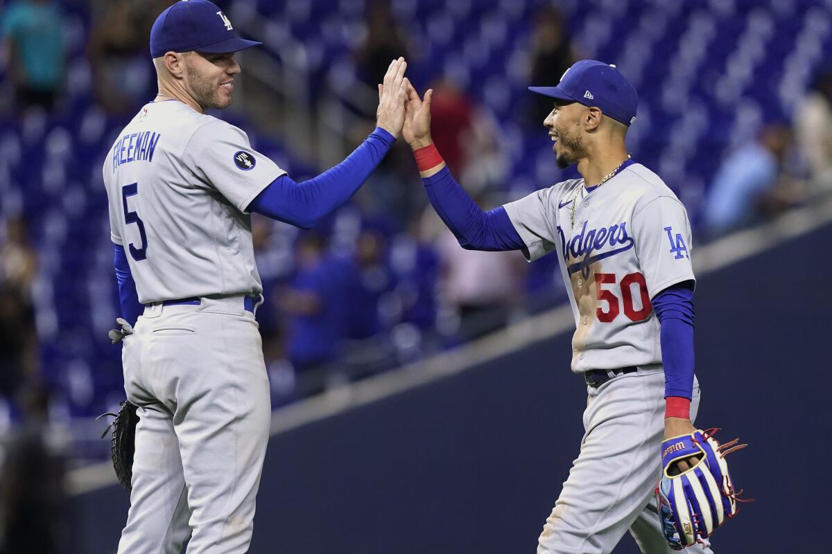 The Dodgers' Mookie Betts, right, and Freddie Freeman celebrate the team's extra-inning win at Miami on Aug. 26, 2022.