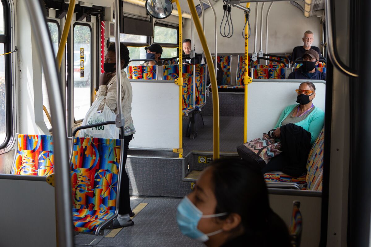 Bus riders in Los Angeles wear masks and sit far apart from one another.
