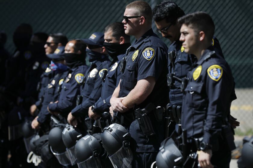 San Diego Police officers stand near police headquarters as a Black Lives Matter protesters gather in the area on June 14, 2020.