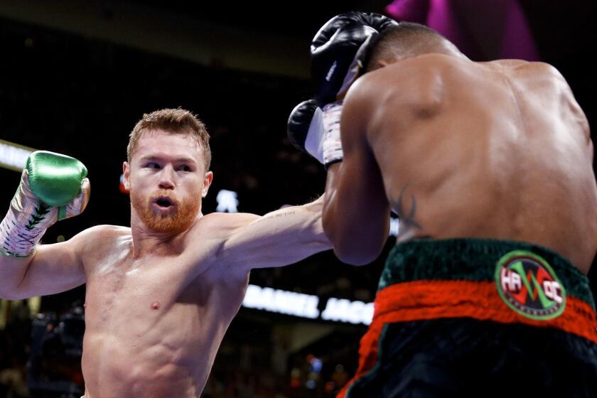 Canelo Alvarez, left, of Mexico, tries to hit Daniel Jacobs with a left during a middleweight title boxing match Saturday, May 4, 2019, in Las Vegas. (AP Photo/John Locher)