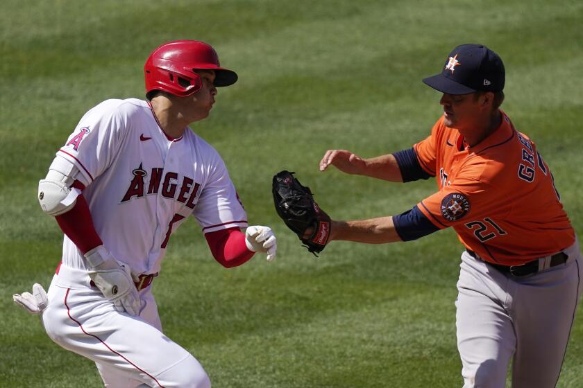 Los Angeles Angels' Shohei Ohtani, left, is tagged out as he runs to first by Houston Astros starting pitcher Zack Greinke during the fifth inning of a baseball game Tuesday, April 6, 2021, in Anaheim, Calif. (AP Photo/Mark J. Terrill)