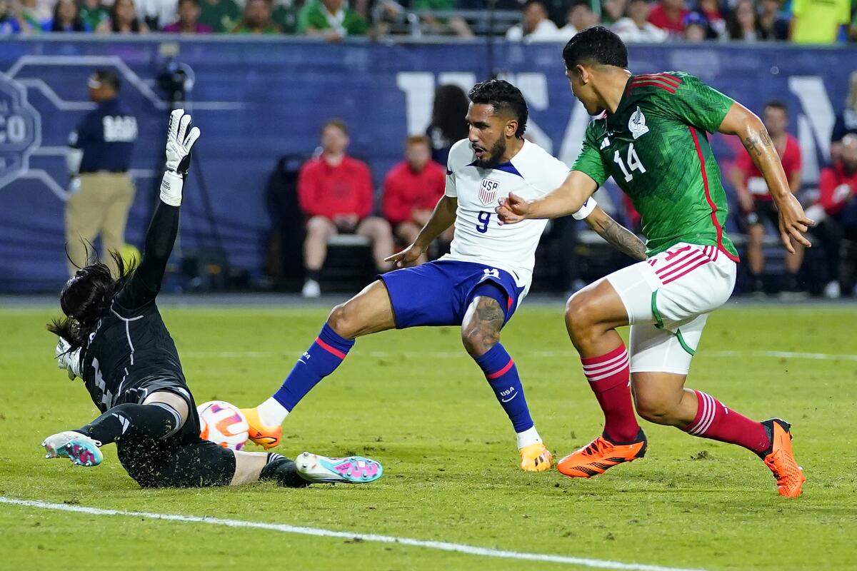 United States' Jesús Ferreira scores a goal as Mexico's goal keeper Carlos Acevedo and Victor Guzman defend.