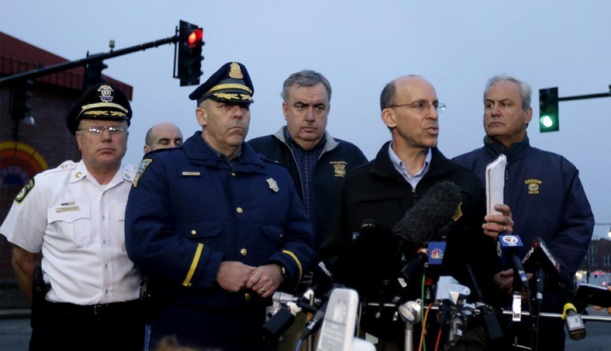 Officials address the media during a news conference in Watertown, Mass., on Friday. CNN has seen huge ratings gains this week.