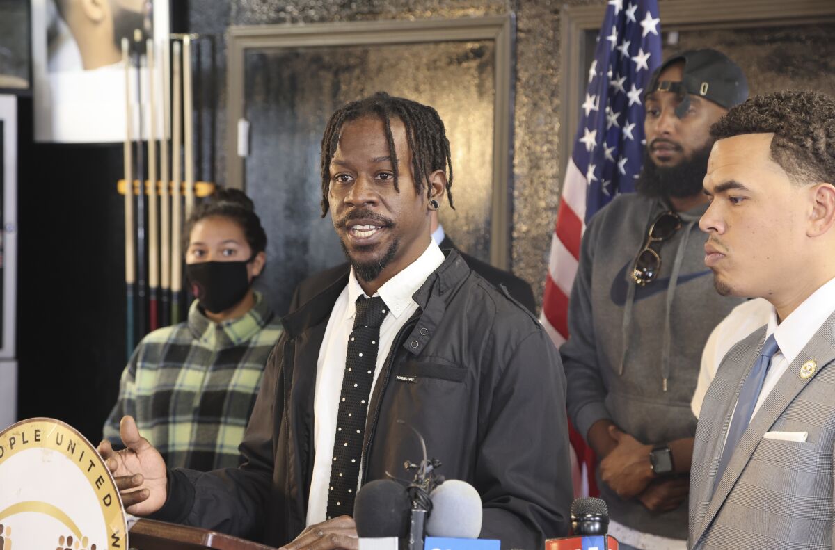 Jeffrey Thornton speaks about his discrimination lawsuit while other people stand nearby