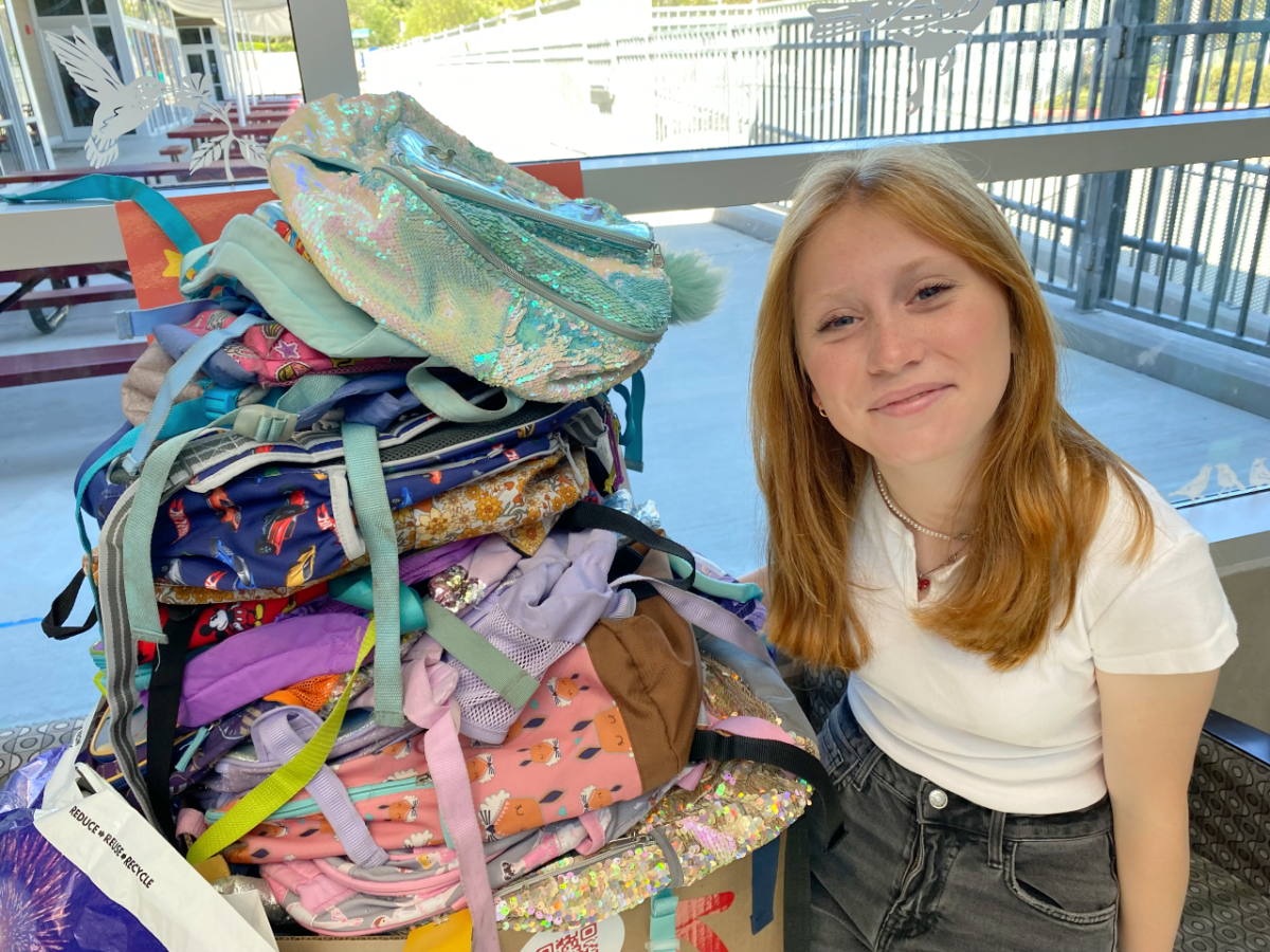 Kalia Roper with some of the donated backpacks.