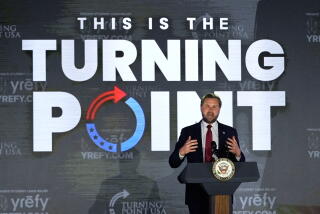 Vice President JD Vance speaks at a college campus event in front of a poster reading "This Is the Turning Point."