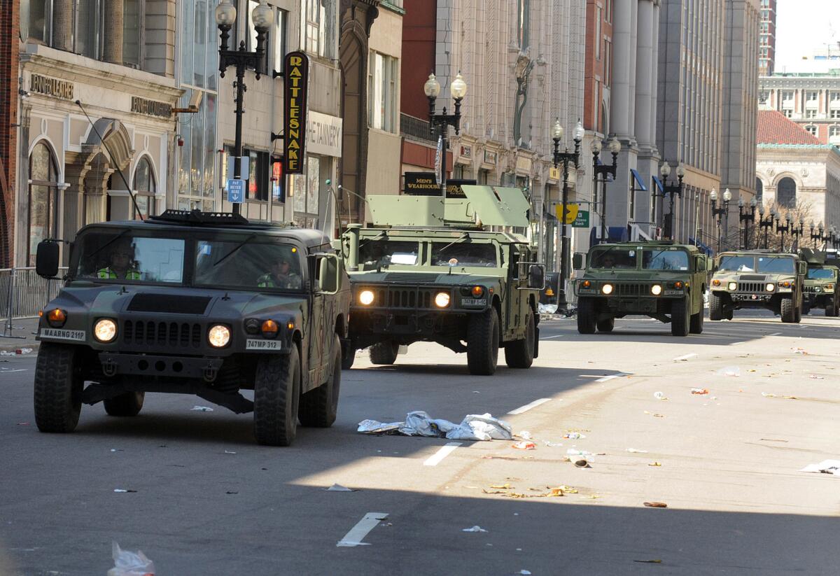 U.S. military Humvees roll down a deserted Boylston Street, which is considered a crime scene after two explosions rocked the Boston Marathon on Monday.