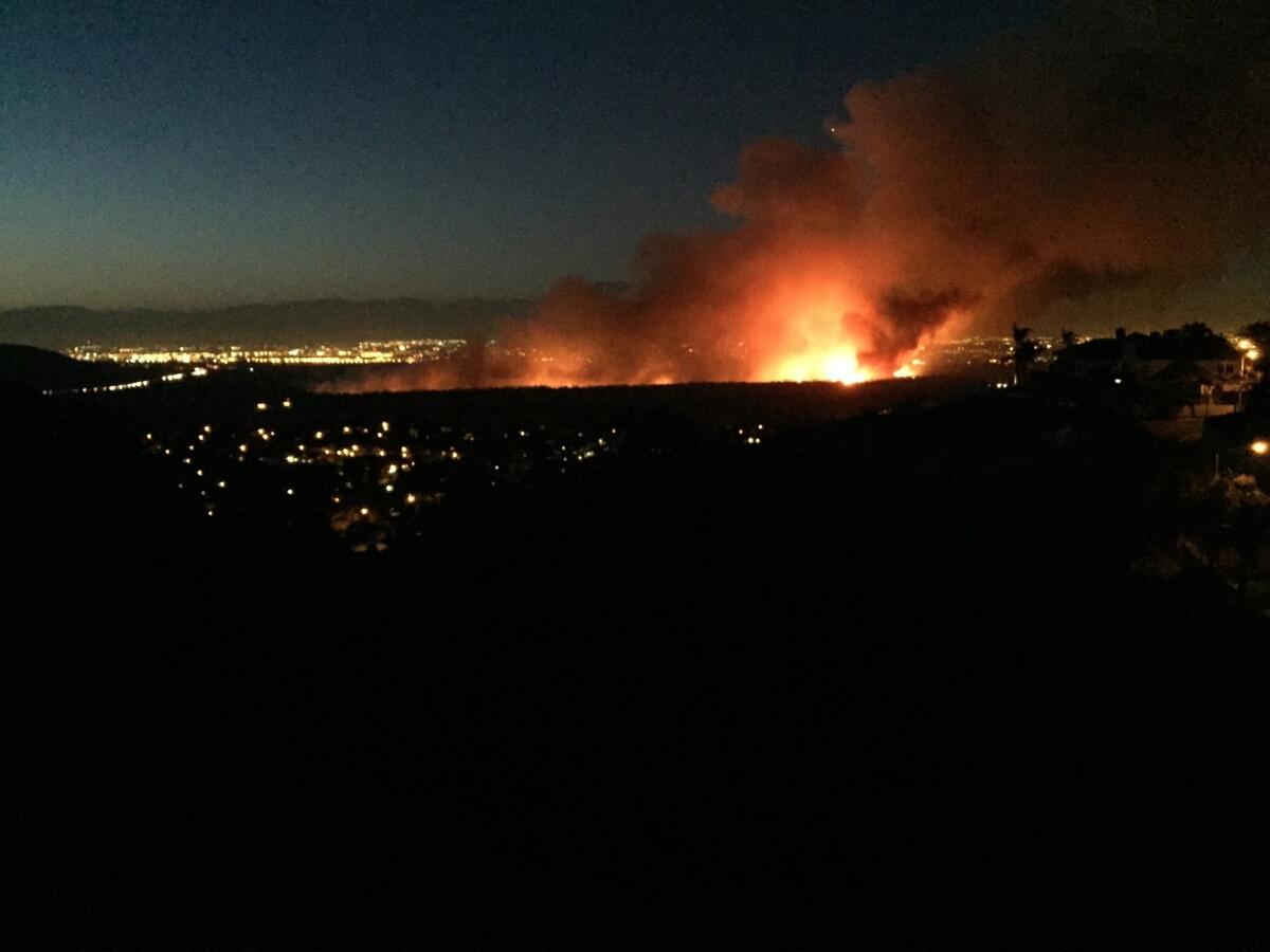 A brush fire burns north of Corona on Saturday night.