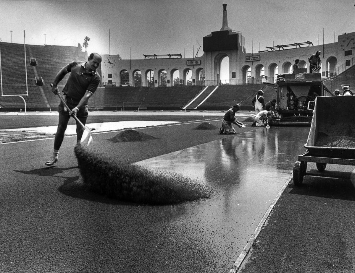 May 24, 1983: Crews from West Germany put the finishing touches on the Dusseldorf-made synthetic track being installed at the Coliseum for the 1984 Olympics. The surface was to be tested at a June 24-25, 1983, dual meet.