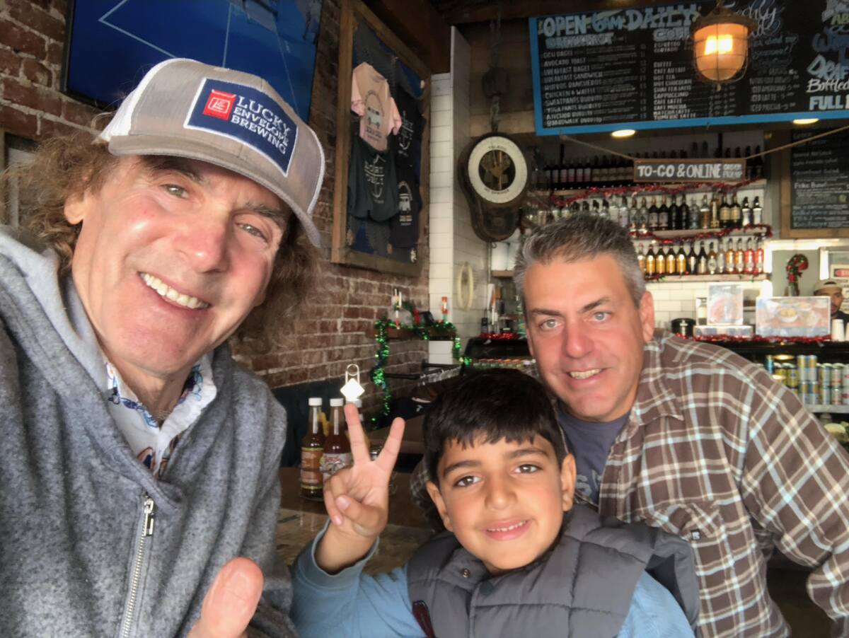 Local radio listener Zorawar "Captain Z" Clark, 6, center, with host Jim "Poorman" Trenton, left, and dad Jack Clark.