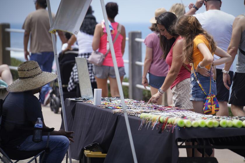SAN DIEGO, CA - JULY 27: Street vendors continue to sell their wares along the sidewalk at and around Ellen Browning Scripps Park in La Jolla, July 27, 2023, not far from Coast Boulevard, although they are violating the city laws preventing it. Vendors are being allowed to violate those laws because the City of San Diego is worried the laws might violate first amendment free speech rights. (Howard Lipin / For The San Diego Union-Tribune)