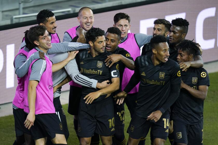 Teammates surround LAFC's Carlos Vela (10) after he scored his second goal against Club America on Dec. 19, 2020.