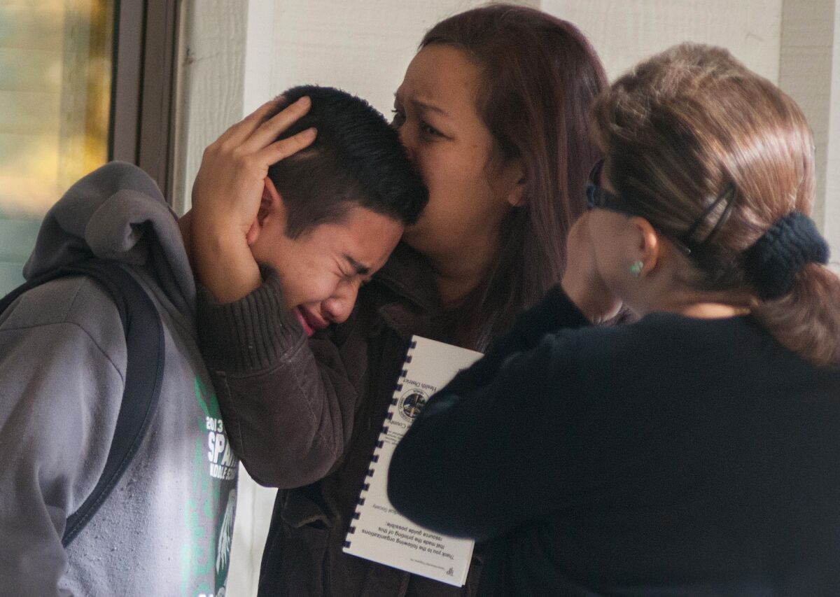 After a shooting at Sparks Middle School, a student is comforted at an evacuation center at nearby Agnes Risley Elementary School in Sparks, Nev.