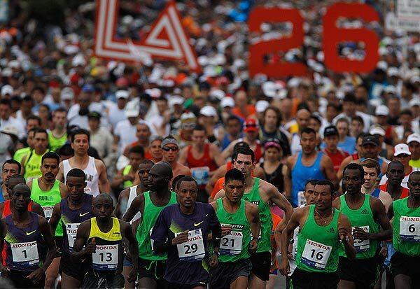 Elite competitors lead a pack of thousands of runners at the start of the L.A. Marathon at Dodger Stadium.
