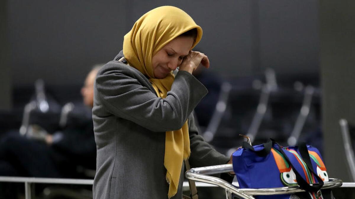 A woman traveling on a flight from Addis Ababa, Ethiopia, wipes away a tear after greeting a relative in the international arrivals area of Washington Dulles International Airport on Feb. 6, 2017.