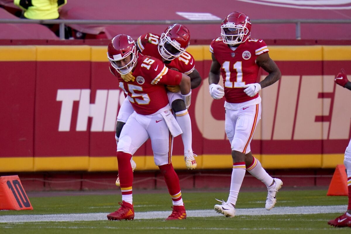 Kansas City Chiefs quarterback Patrick Mahomes (15) gives wide receiver Tyreek Hill (10) a ride on his back to the bench as wide receiver Demarcus Robinson (11) looks on following Hill's touchdown catch in the second half of an NFL football game against the New York Jets on Sunday, Nov. 1, 2020, in Kansas City, Mo. (AP Photo/Jeff Roberson)