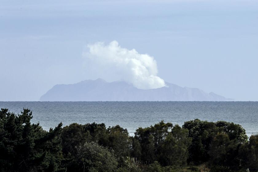 FILE - Plumes of steam rise above White Island off the coast of Whakatane, New Zealand, on Dec. 11, 2019, following a volcanic eruption on Dec. 9. Three helicopter tour operators pleaded guilty on Friday, July 7, 2023, to safety breaches when New Zealand’s White Island volcano erupted in 2019, claiming 22 lives. (AP Photo/Mark Baker, File)