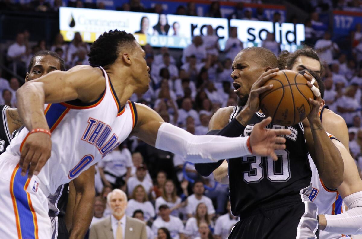 Spurs forward David West (30) reacts as Thunder guard Russell Westbrook (0) tries to steal the ball during the first half of Game 4 of a second round playoff game on May 8.