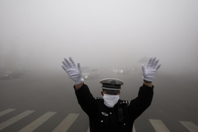 A policeman works on a street in heavy smog in Harbin, in northeast China, on Oct. 21, 2013.