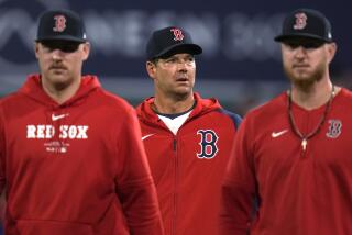 Red Sox pitcher Rich Hill, center, walks near two teammates on a baseball field.