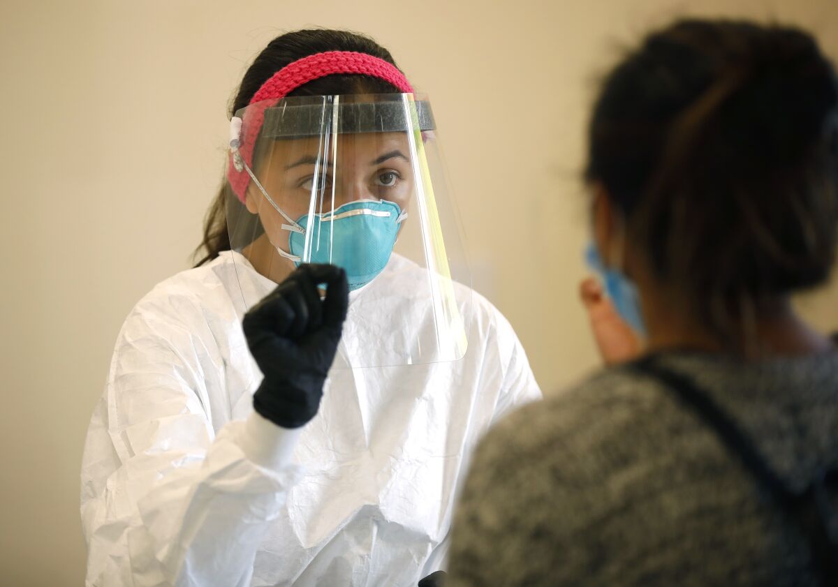 Vivianna Hernandez monitors a COVID-19 test at Cal State San Marcos, one of the busiest testing centers in San Diego County