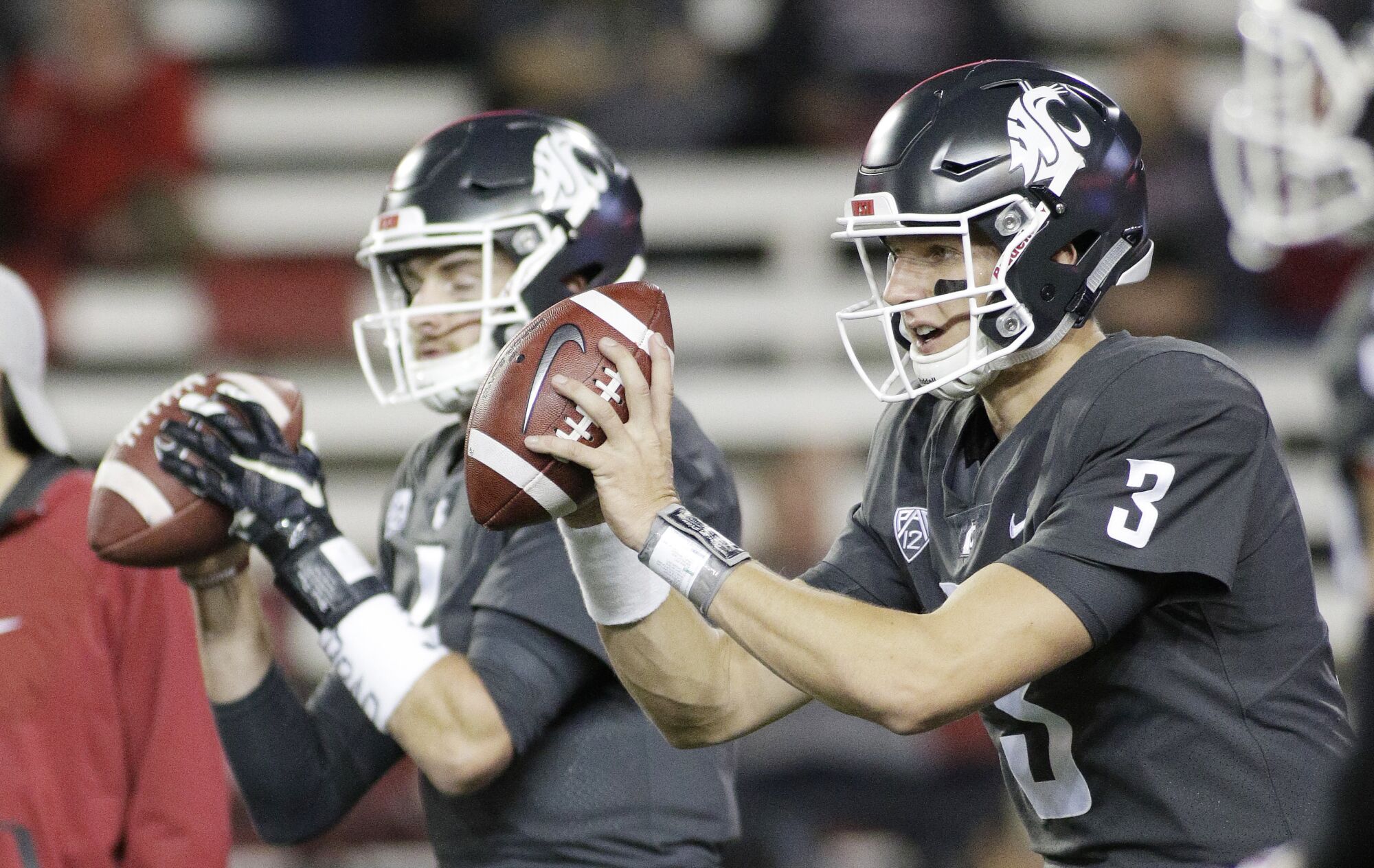 Cougars quarterbacks Tyler Hilinski (3) and Luke Falk take snaps during warmups before a game against USC in Pullman.