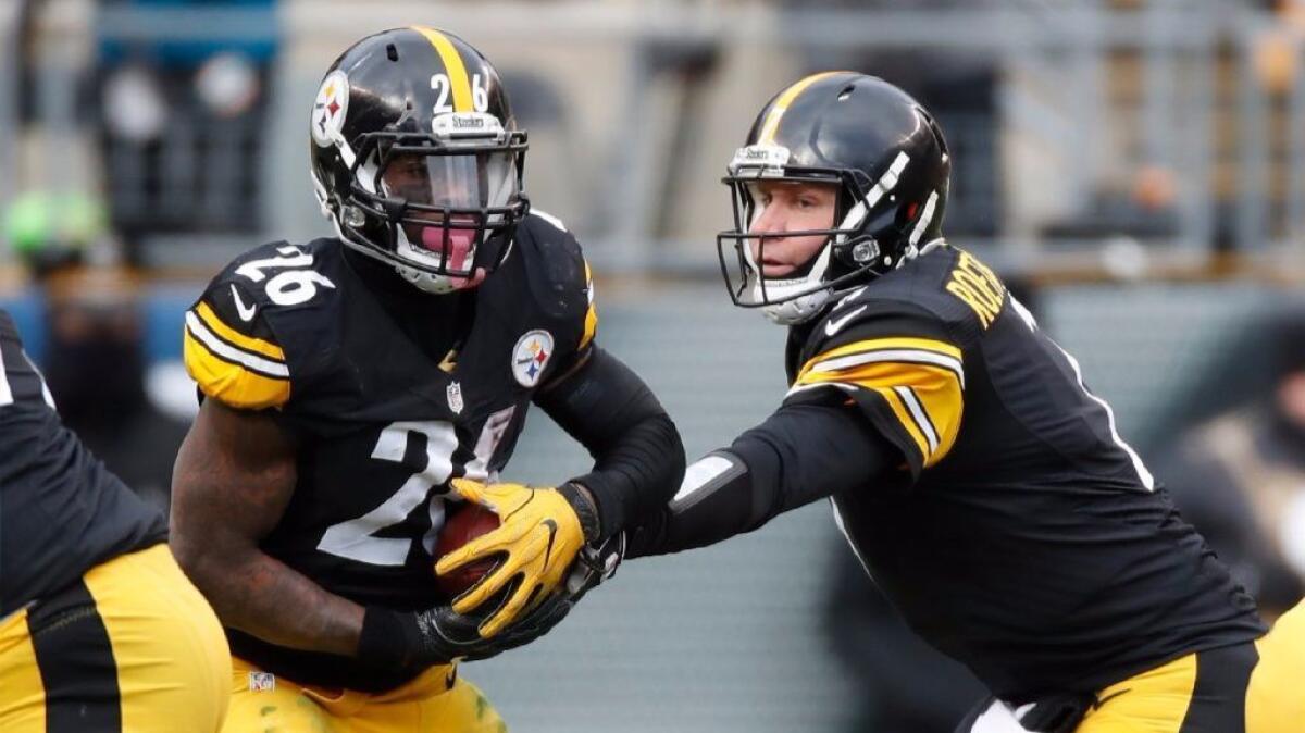 Steelers running back Le'Veon Bell takes the handoff from quarterback Ben Roethlisberger during the second quarter of a playoff game in Pittsburgh on Jan. 8.