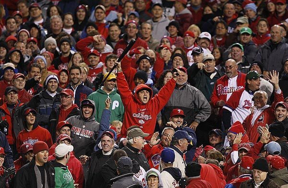 A Phillies fan exalts after retrieving a bat accidently thrown into the seats by Phillies center fielder Shane Victorino as he swung and missed a Chad Billingsley pitch in the fifth inning of Game 3 of the NLCS at Citizens Bank Park on Sunday night.