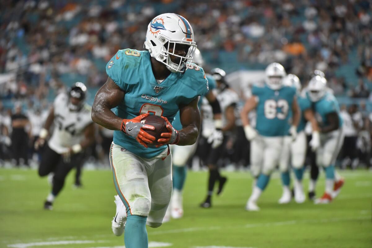 Mark Walton scores a touchdown during a preseason game against the Jacksonville Jaguars on Aug. 22. He was released Tuesday by the Miami Dolphins.
