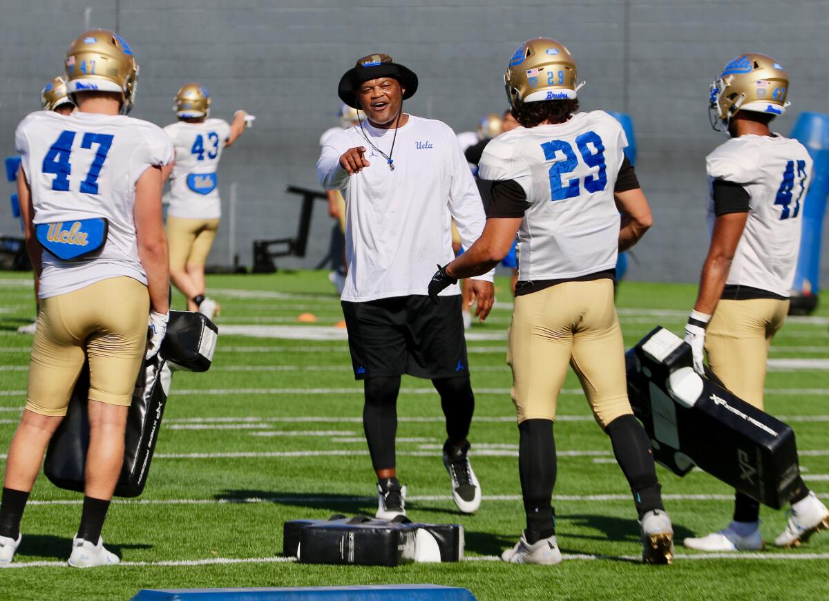 UCLA linebackers coach Ken Norton Jr. gives instructions to linebackers Shea Pitts and Adam Cohen at spring practice.