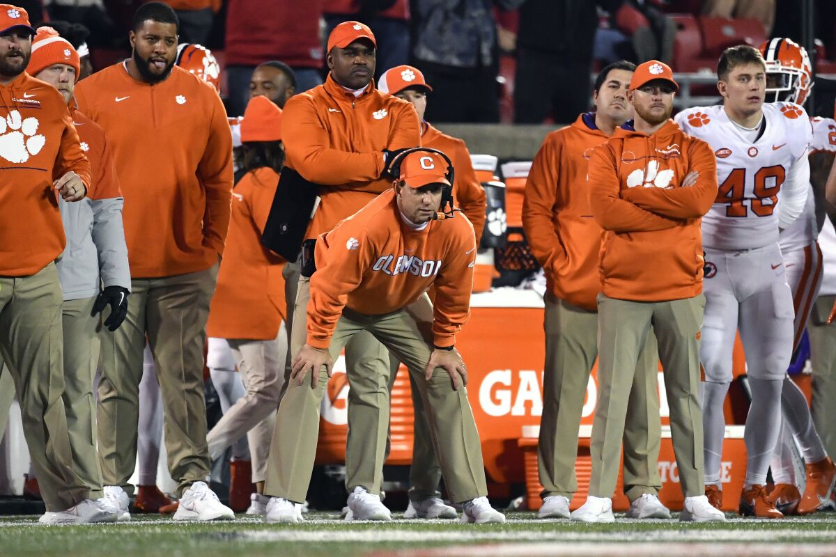 Clemson coach Dabo Swinney, center, watches during the second half of the team's NCAA college football game against Louisville in Louisville, Ky., Saturday, Nov. 6, 2021. Clemson won 30-24. (AP Photo/Timothy D. Easley)