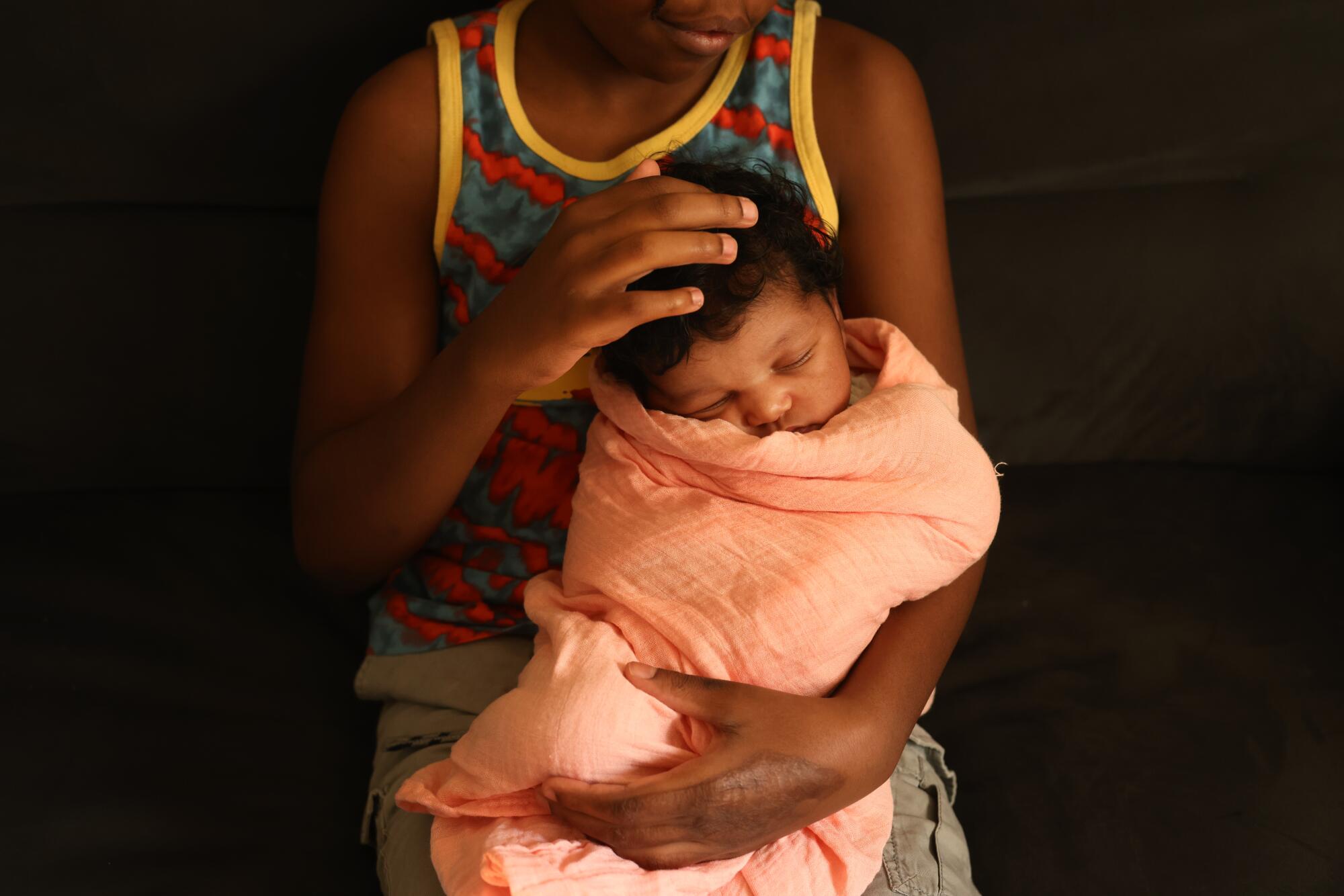 A young man holds his baby sister