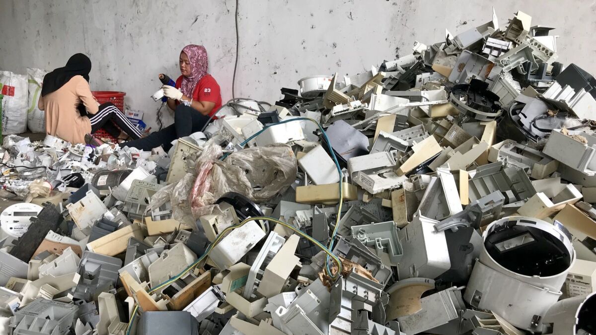 Workers dismantle plastic waste from the U.S. and other countries at a warehouse in Port Klang, Malaysia.