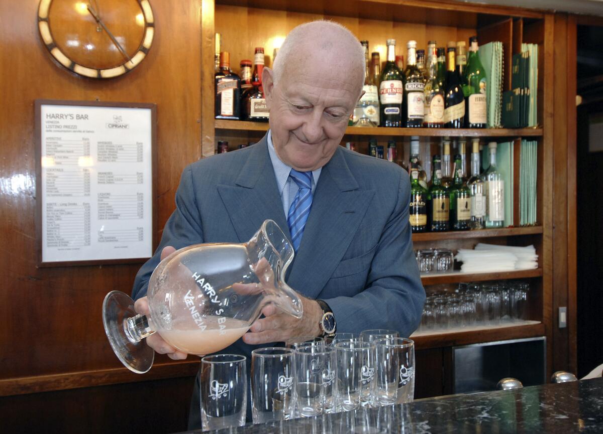 Arrigo Cipriani pours peach juice into Champagne flutes while making Bellinis at Harry's Bar in Venice in 2006.